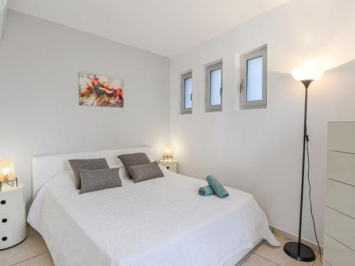 - une chambre blanche avec un lit blanc et 2 fenêtres dans l'établissement Apartment Dolce Vita by Interhome, à Saint-Laurent-du-Var