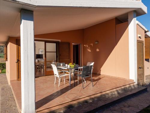 a deck with a table and chairs on a house at Holiday Home Alma by Interhome in Castiglione della Pescaia