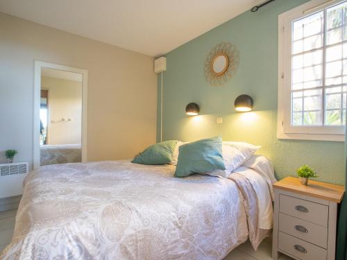 une chambre avec un lit, une fenêtre et un miroir dans l'établissement Apartment L'Esquinade - G3 033 by Interhome, à Agay