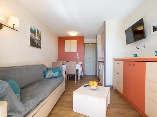 un salon avec un canapé et une cuisine dans l'établissement Apartment L'Esquinade - P6 323- place des pêcheurs by Interhome, à Agay