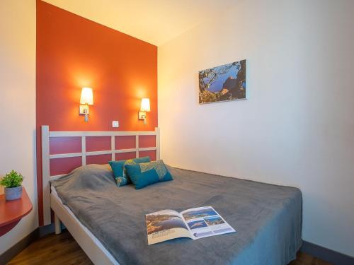- une chambre avec un lit et un livre dans l'établissement Apartment L'Esquinade - P6 323- place des pêcheurs by Interhome, à Agay