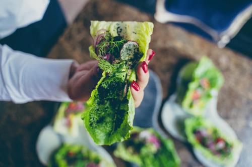 a person holding a piece of food with greens on it at Can Bordoy Grand House Hotel GL Preferred Hotel in Palma de Mallorca