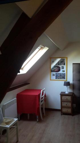 a room with a red table in a attic at Au Gallodrome Maison d'hôtes et Table d'hôtes en Estaminet privé in Drincham