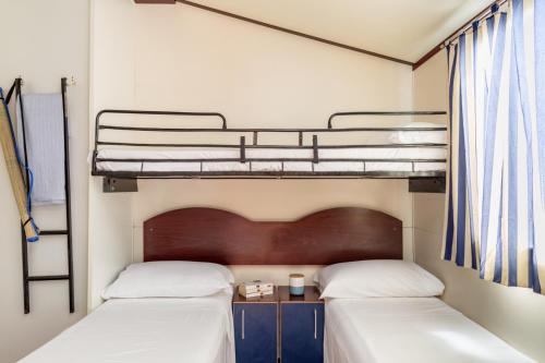a bedroom with two bunk beds and a desk at Comfort Lodge Maremma in Grosseto