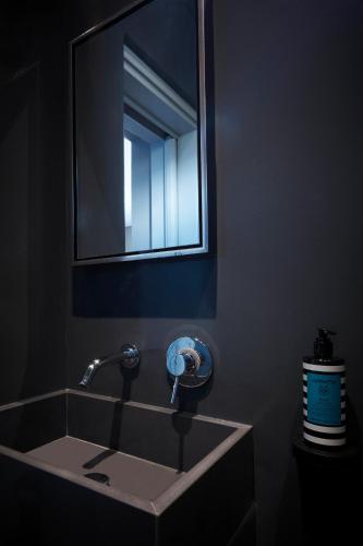 a bathroom sink with a faucet and a mirror at My Santorini Villa, Pyrgos Luxury in Pirgos