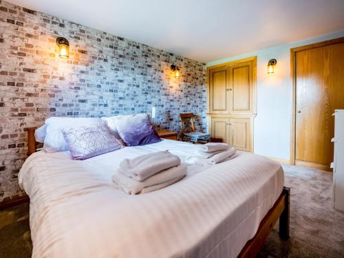um quarto com uma cama grande e toalhas em Pass the Keys Superb 3 Bedroom Cottage with Sea Views em Anstruther