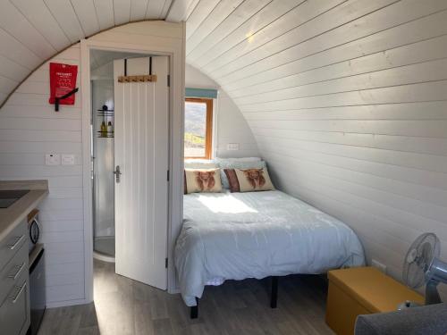 ein Schlafzimmer mit einem Bett in einem weißen Zimmer in der Unterkunft Duirinish Pods with Private Hot Tubs and Duirinish Bothy with No Hot Tub in Plockton