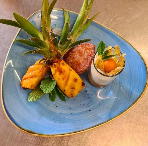 a blue plate of food with a pineapple on it at Hotel Zur Post in Pirna