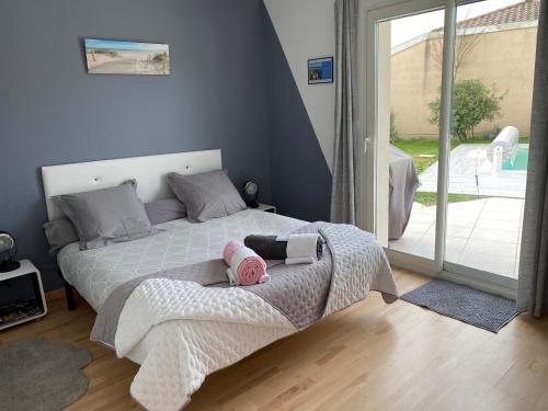 een slaapkamer met een bed met twee poppen erop bij Le Teich Tranquille in Le Teich