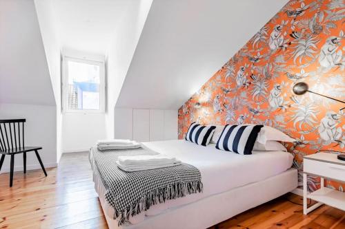 a bedroom with a bed with an orange wall at Downtown - Chiado & Me 2 in Lisbon