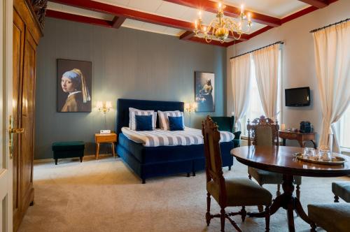 ein Schlafzimmer mit einem Bett und einem Tisch sowie ein Esszimmer in der Unterkunft Herberg Het Rechthuis in Rinsumageest