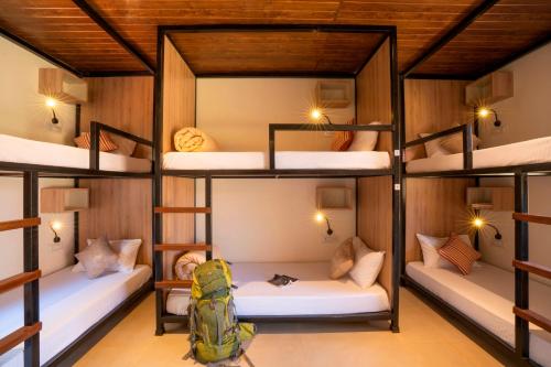 a room with four bunk beds with a backpack at Zostel Plus Lonavala in Lonavala
