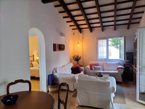 a living room with white furniture and a wooden ceiling at Grupoandria Villa Julia in Cala en Forcat