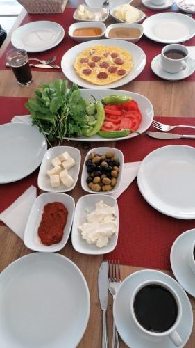 einen Tisch mit weißen Tellern. in der Unterkunft Luna Piena Hotel in Anamur