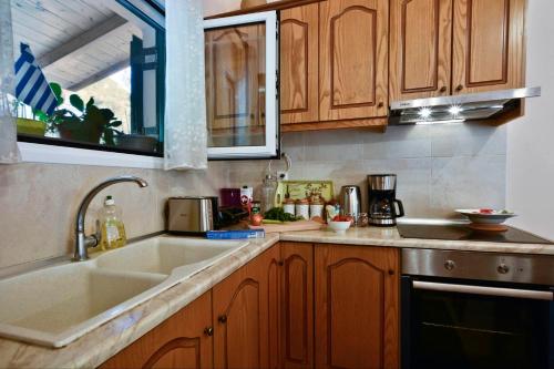 a kitchen with wooden cabinets and a sink at Sunset Cottage in Paramonas
