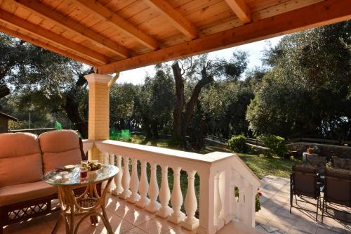 a porch with a wooden roof and a table and chairs at Sunset Cottage in Paramonas