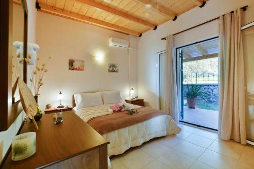 a bedroom with a bed and a desk and a window at Sunset Cottage in Paramonas