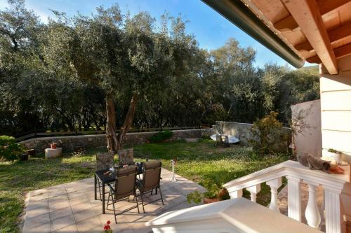 a patio with a table and chairs and a tree at Sunset Cottage in Paramonas