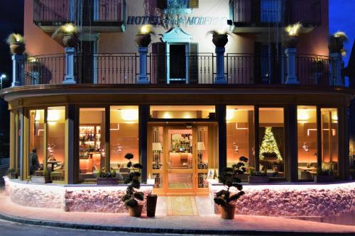 een winkel voor een gebouw met een kerstboom bij Hotel Moderno Restaurant in Serina