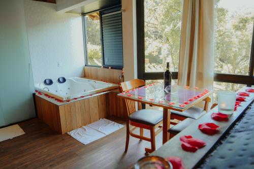 a room with a bath tub and a table with a table sidx sidx at Terrazzo dos Alpes in Monte Verde