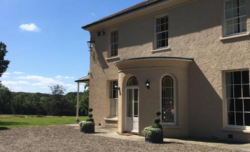 a house with a white door and a yard at Gardener's Cwtch, Llwynhelig Manor in Llandeilo