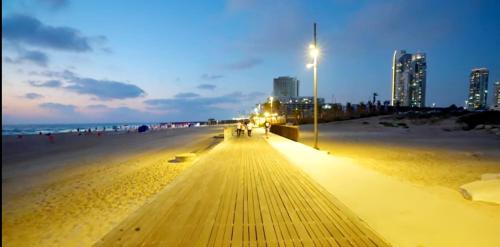 a boardwalk on a beach at night at Hotel Apartment Short Term Tel Aviv Bat Yam 5 in Bat Yam