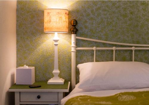un lit avec une lampe sur une table de chevet à côté d'un lit sidx sidx dans l'établissement The Lakes B and B, à Ambleside