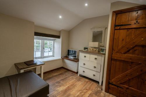 a bedroom with a bed and a window and a wooden door at Grapes Hotel, Bar & Restaurant Snowdonia Nr Zip World in Blaenau-Ffestiniog
