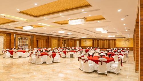 a large banquet hall with red and white tables and chairs at Playotel Resort Bhopal in Bhopal