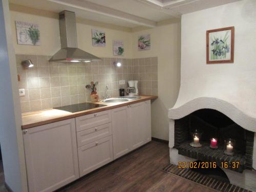 - une cuisine avec une cheminée dans l'angle d'une pièce dans l'établissement Le cosy d'Honfleur, à Honfleur