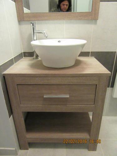 La salle de bains est pourvue d'un lavabo et d'une personne dans un miroir. dans l'établissement Le cosy d'Honfleur, à Honfleur