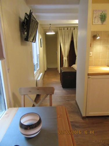 un salon avec une table et une chambre avec une cuisine dans l'établissement Le cosy d'Honfleur, à Honfleur