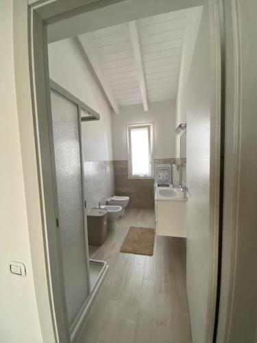 een badkamer met 2 toiletten, een wastafel en een spiegel bij Domus de Victoria in Càbras