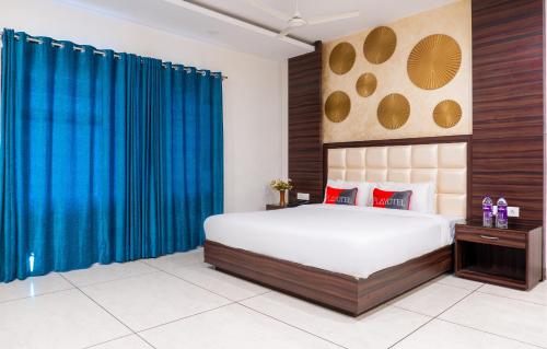 a bedroom with a large bed with blue curtains at Playotel Resort Bhopal in Bhopal