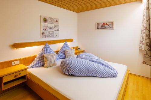 a bedroom with a bed with blue and white pillows at Ferienwohnungen Gastager in Ruhpolding