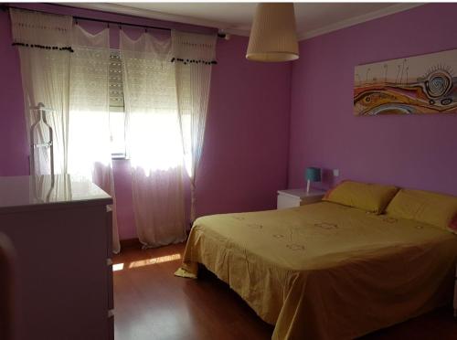 a purple bedroom with a bed and a window at Pura vida en Sevilla in Seville
