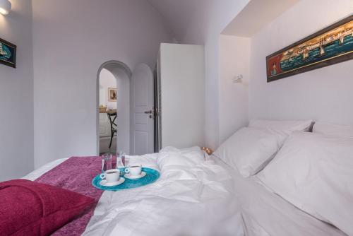 a white bed with a tray with drinks on it at Kastro Mansion in Pirgos