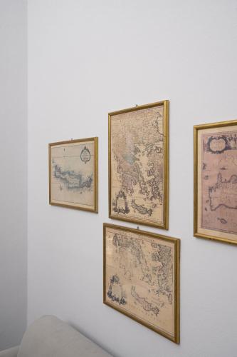 a group of four framed maps on a wall at Kastro Mansion in Pirgos