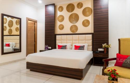a bedroom with a large bed and a chair at Playotel Resort Bhopal in Bhopal