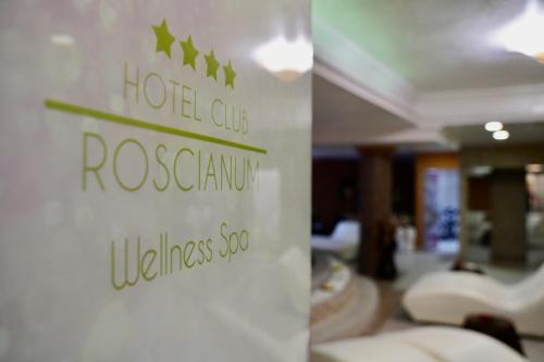 a sign in a hotel lobby with white chairs at Hotel Roscianum Welness SPA in Rossano
