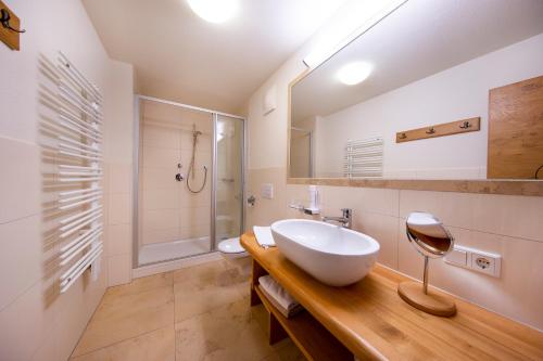 a bathroom with a white sink and a shower at Apartmenthaus Berndlalm in Neukirchen am Großvenediger
