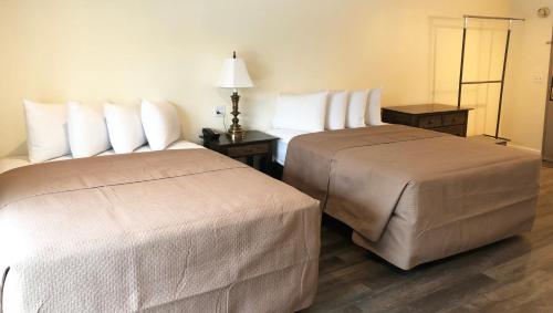 two beds in a hotel room next to each other at Colonial Inn Ellsworth in Ellsworth