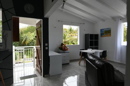 a living room with a door and a table at Gray Coconut Sorbet, T3 tout équipé avec parking gratuit in Le Moule