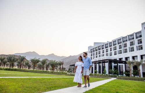 a couple standing in front of a hotel at InterContinental Fujairah Resort by IHG in Al Aqah