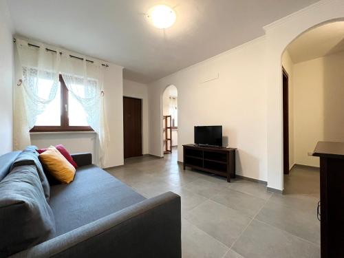 a living room with a couch and a television at Country Holidays Residence in Santa Maria di Castellabate