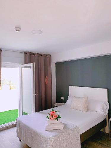 a bedroom with a bed with a flower arrangement on it at Hostal El Castillo Alcala De Guadaira in Alcalá de Guadaira