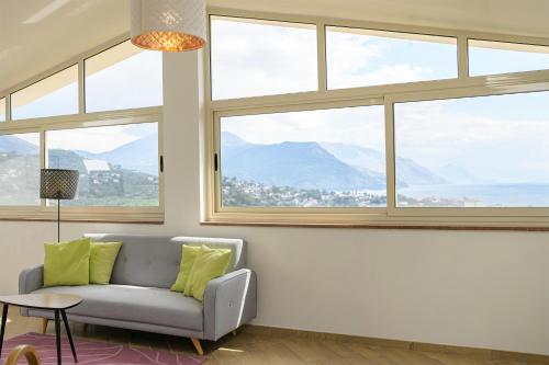 a living room with a couch and large windows at Le Voyageur Cilento in Vibonati