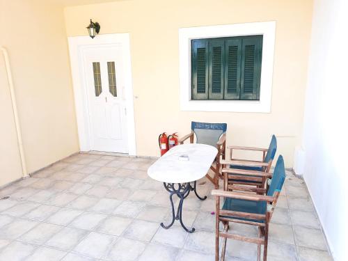 a table and chairs in a room with a window at Panorama Apartments Fiscardo in Fiskardho