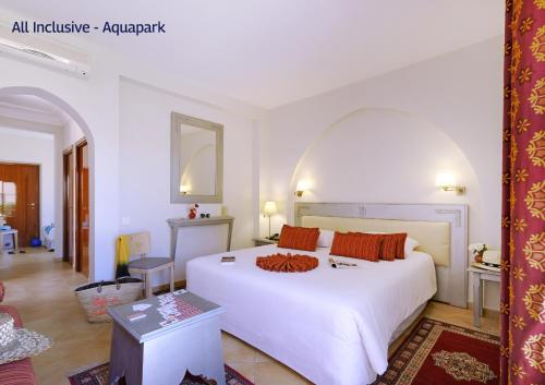 a bedroom with a large white bed with orange pillows at Valeria Dar Atlas All Inclusive in Marrakech