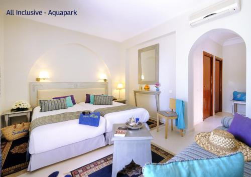 a hotel room with two beds and a couch at Valeria Dar Atlas All Inclusive in Marrakech
